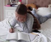Get 100&#39;s of FREE Video Templates, Music, Footage and More at Motion Array: http://bit.ly/2SITwWM nnnGet this here: https://motionarray.com/stock-video/school-girl-doing-homework-199881nnThe School Girl Doing Homework stock video is a fine piece of video that displays a Caucasian school girl doing homework while lying on her bed. This 3840x2160 (4K) bit of video is ideal to use in any project that has to do with school, education, child development, etc. This video will look great in your next v